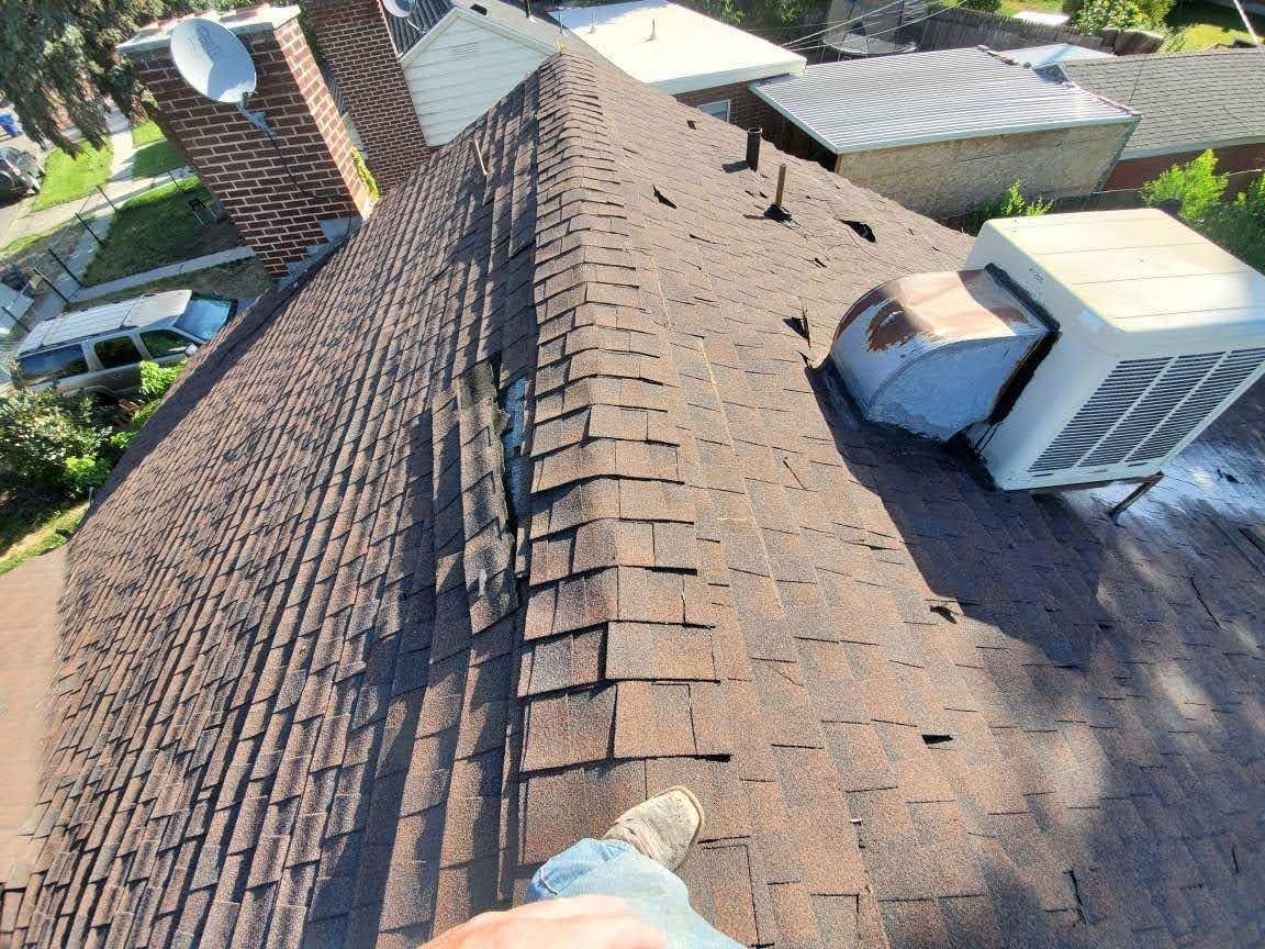 Worn asphalt shingle roof with torn, lifted shingles, brick chimney and rooftop evaporative cooler; a boot at bottom, in Draper, UT